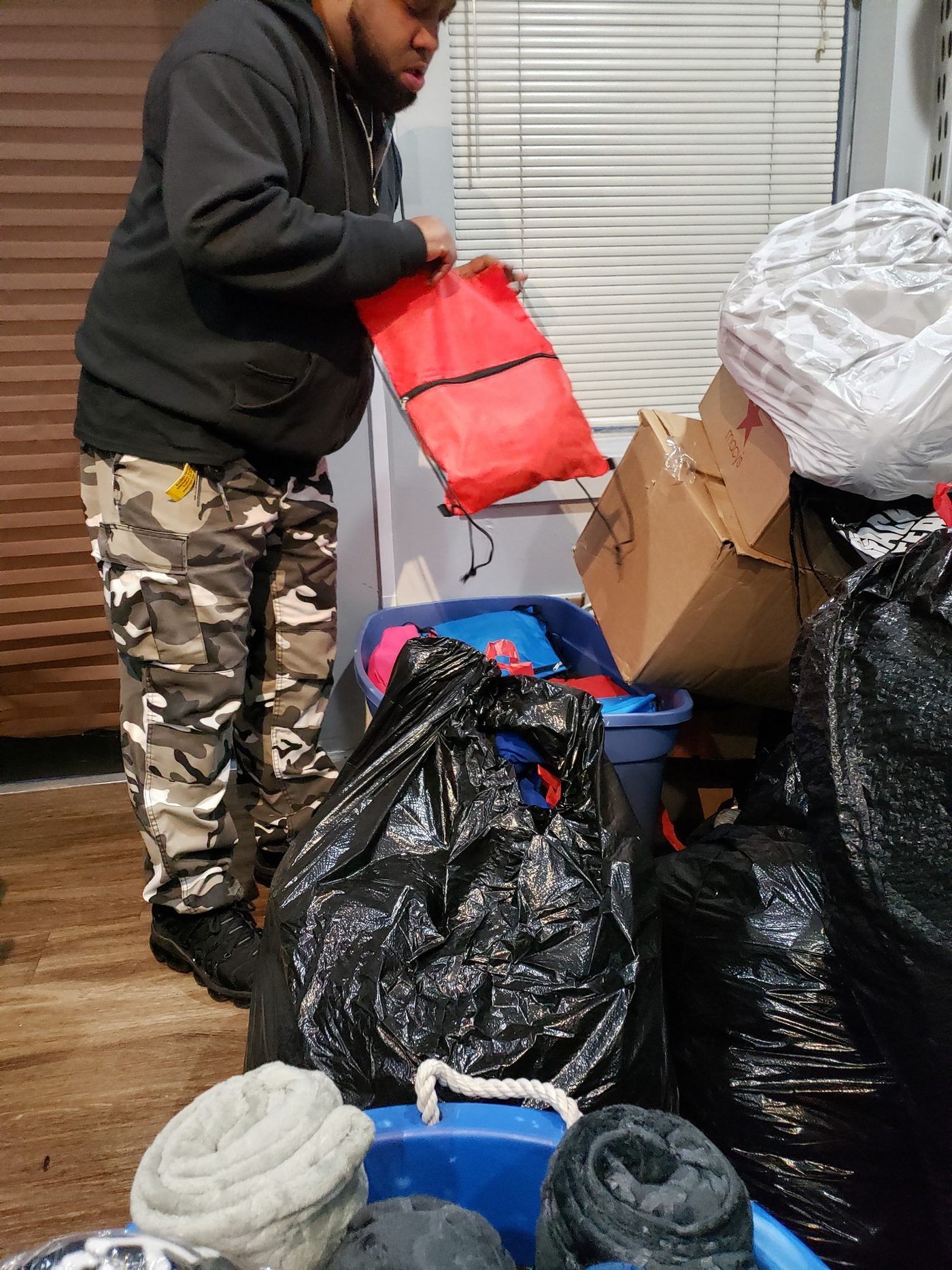 A volunteer filling drawstring bags with supplies