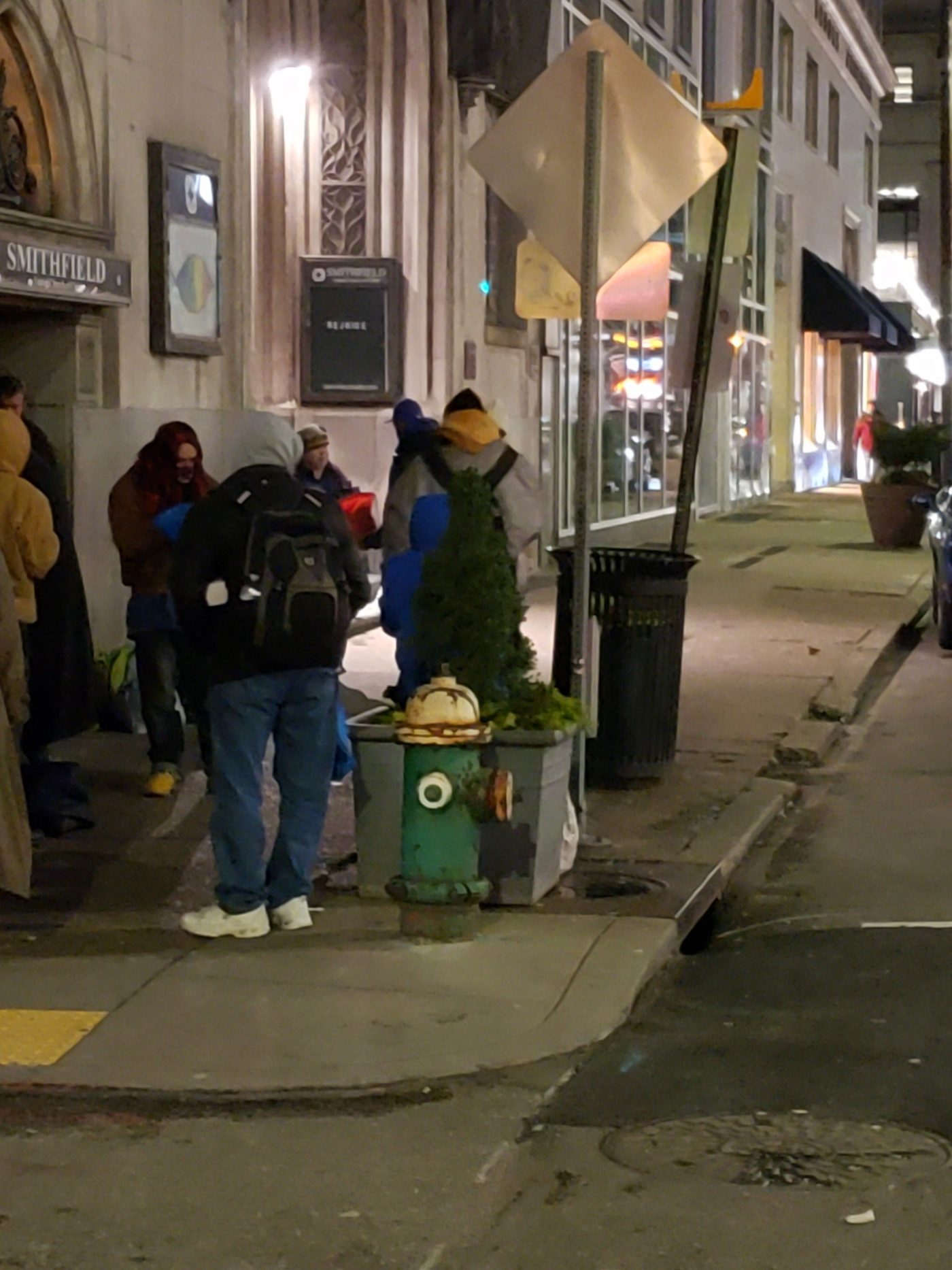 People gathering on a downtown Pittsburgh sidewalk to receive supplies
